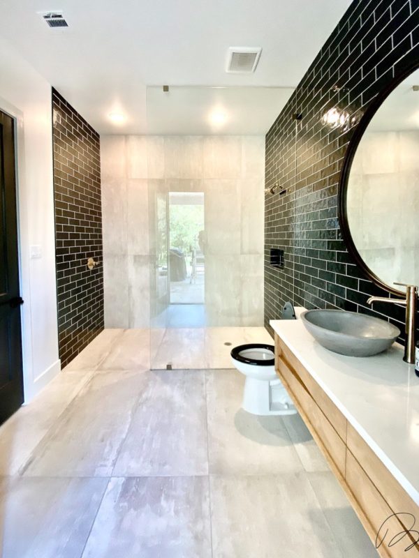 Large stone tile bathroom with black tile walls and custom shower installed by Floored by Barrett in the Temple Belton area