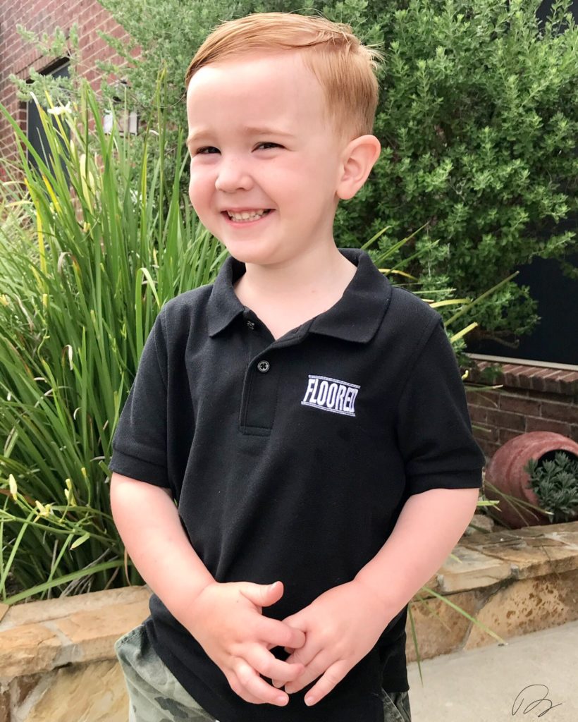 Barret Hines Son wearing Floored by Barret Company Logo on black polo