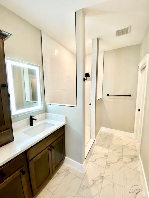 White Tile shower in bathroom with white marble tile floor installed by Floored by Barrett in the Temple Belton area