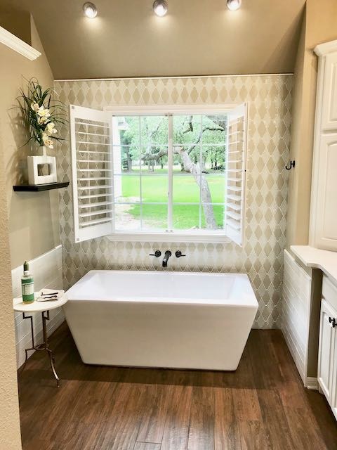 Hardwood bathroom floor and white rectangular tub installed by Floored by Barrett in the Temple Belton area
