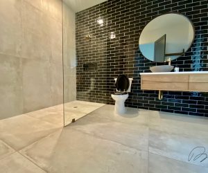 Large stone tile bathroom with black tile walls and custom shower installed by Floored by Barrett in the Temple Belton area